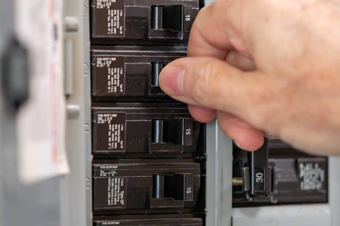 A person testing their new electrical panel replacement.